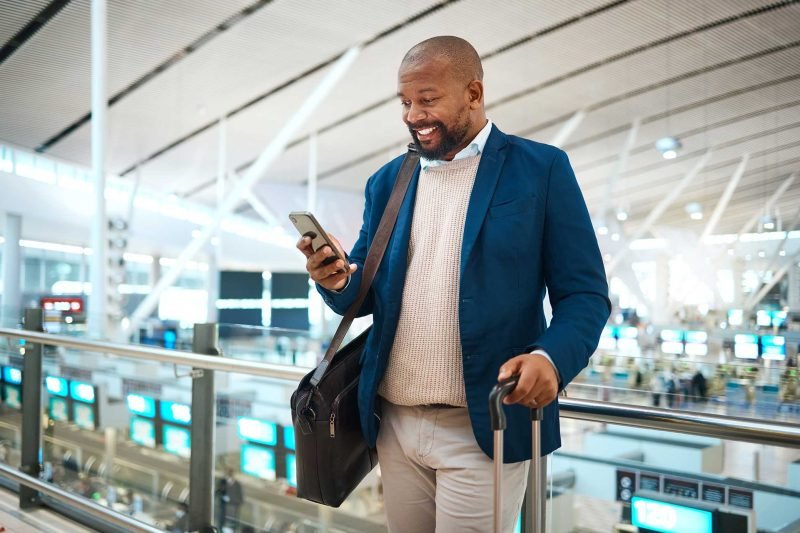 black-man-with-phone-airport-and-online-check-in-o-7JVR6SV.jpg